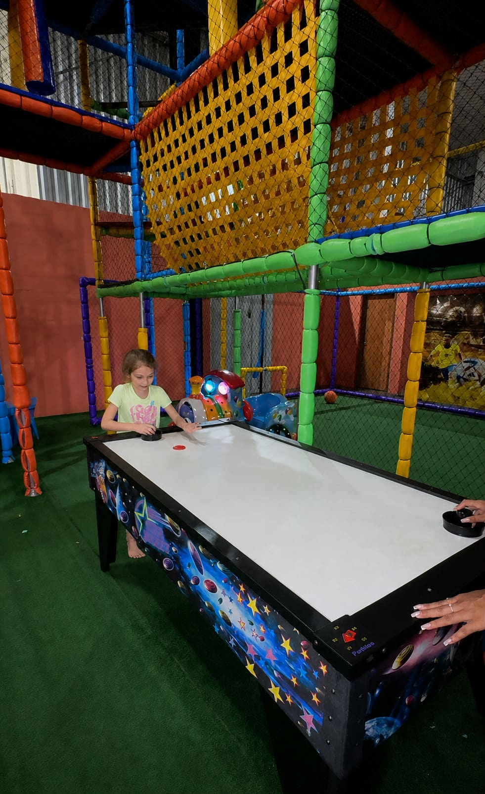 Criança brincando de air hockey no espaço kids da Italiamo Capicche